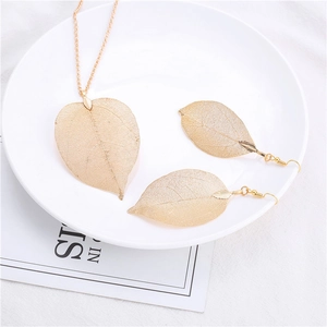Golden filigree leaf necklace and earrings jewelry set for women on white background