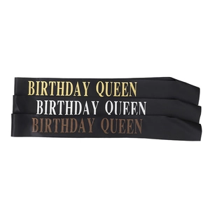 Detail view of three black satin Birthday Queen sashes with gold, silver and rose gold foil