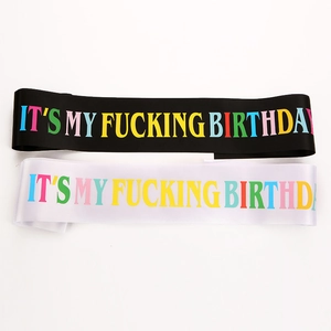 Detail of black and white satin birthday girl sashes with colorful printed lettering