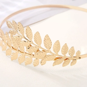 Macro detail of golden metal laurel leaf headpiece showing intricate leaf textures
