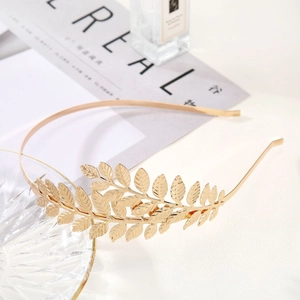 Detail of golden leaf headband with intricate vein texture and metallic finish