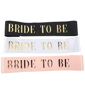 Close-up of three satin sashes in black, white, and pink with gold Bride to be foil stamping