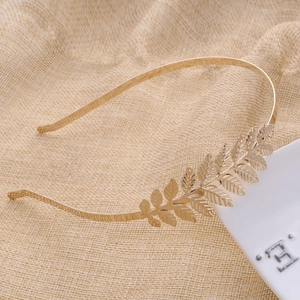 Close-up of golden metal laurel leaf headband showing intricate leaf vein textures