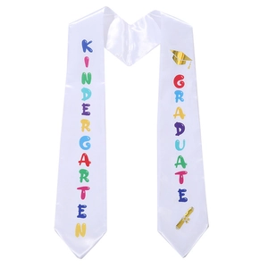Detail of white satin kindergarten graduate sash with colorful print and golden motifs