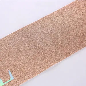 Close-up of rose gold glitter ribbon with fine texture and shimmering particles