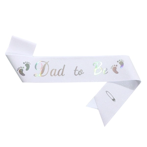 Close-up of white glitter Dad to Be sash with iridescent text and silver safety pin