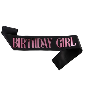 Detail of black satin Birthday Girl sash with shimmering pink metallic foil lettering