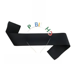 Close-up of black satin sash and metal headband with colorful Happy Birthday lettering