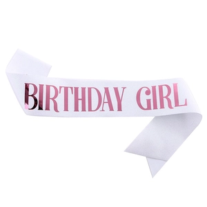 Detailed view of white glitter fabric sash with rose gold Birthday Girl lettering
