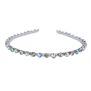 Détail d'un serre-tête fin en métal argenté orné de strass irisés aux reflets arc-en-ciel