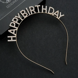 Detail of gold metal birthday headband with white rhinestones spelling HAPPY BIRTHDAY