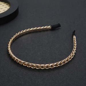 Elegant gold metal chain headband for women with black fabric comfort ends on dark background