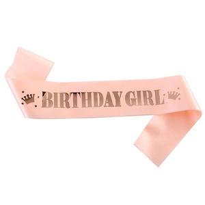 Pink satin Birthday Girl sash with shimmering gold lettering and crown icons for parties