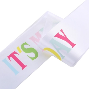 Close-up of white satin birthday sash with colorful IT'S MY DAY text and silky texture