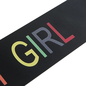 Close-up detail of black fabric sash with colorful Girl text for birthday party decoration
