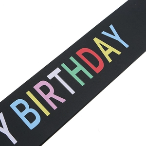 Detailed macro view of black matte birthday sash with colorful Happy Birthday printed text