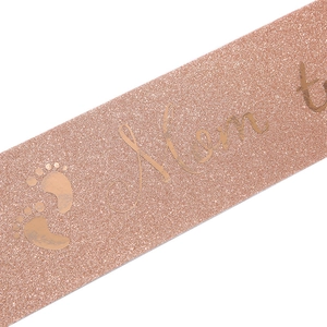Close-up of rose gold Mom To Be sash with glitter texture and baby footprints for baby showers