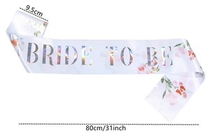 Dettaglio della fascia Bride to Be in raso bianco con scritte oro e fiori ad acquerello