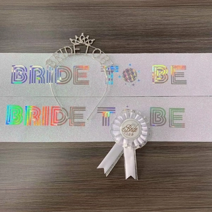 Detailed set view of Bride to Be accessories with lace badge, sash, and tiara on wood