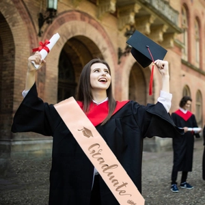 Detailed macro view of champagne gold satin graduate sash with elegant gold lettering