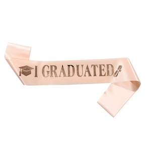 Close-up of pink satin graduation sash with I GRADUATED gold foil text and graduation icon