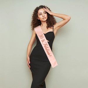 Pink satin birthday sash featuring 30 and Fabulous text for women party accessories