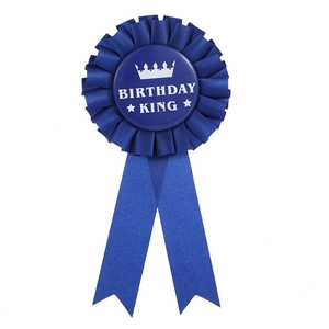 Détail de la cocarde bleue Birthday King avec motif couronne et rubans en satin