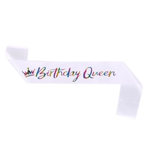 Close-up of white satin birthday queen sash with colorful gradient lettering and crown