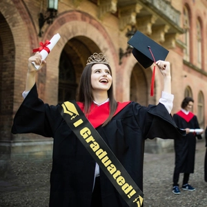Detail of graduation kit with I Graduated sash, black cap, silver crown and diploma scroll