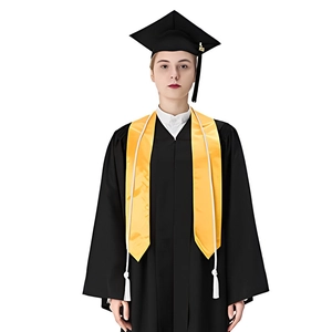 Detail of black graduation gown and cap set with bright yellow ceremonial sashes and tassels