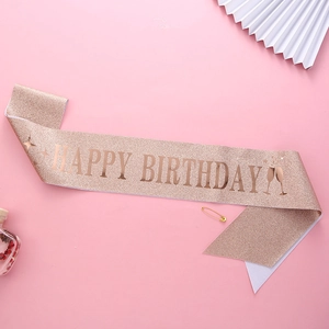 Rose gold glitter happy birthday sash with metallic lettering and gold safety pin detail