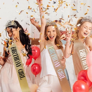 Women wearing Birthday Girl glitter sash and rhinestone tiara set at a party