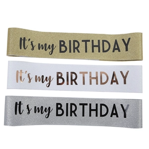 Dettaglio delle fasce di compleanno glitterate in tessuto oro, bianco e argento