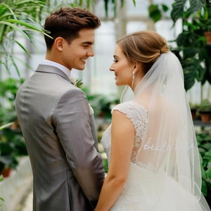 Elegant white bridal veil with Bride to Be embroidery and lace trim in a romantic setting