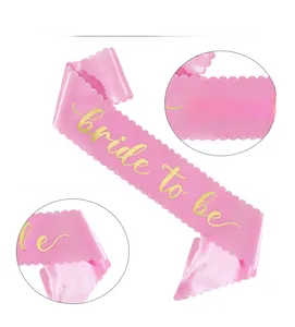 Detail of pink satin bridal sash with scalloped edges and gold foil Bride To Be text