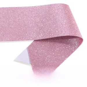Close-up of pink glitter fabric with shimmering texture for DIY party sash decoration