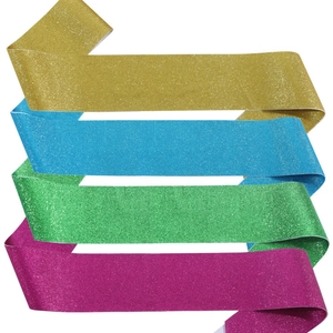 Detail of glitter fabric party sashes in gold, blue, green and rose pink colors