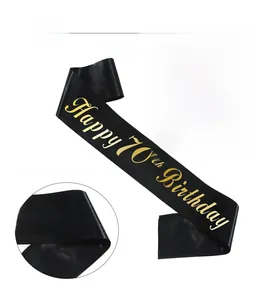 Detail of black satin sash with gold foil Happy 70th Birthday text for party celebration