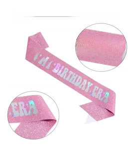 Detailansicht aus rosa Glitzerstoff mit goldenem IN MY BIRTHDAY ERA Aufdruck am Schärpe