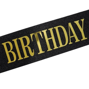 Detail of black glitter Birthday King sash with gold foil text for party celebrations