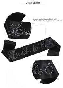Detail of black satin bride to be sash with sparkling rhinestone lettering and diamond icon