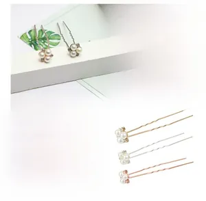 Vue macro d'épingles à cheveux en U avec perles nacrées et strass dorés et argentés