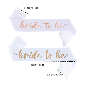Detailed view of white satin Bride to Be sashes with rose gold text and size markings