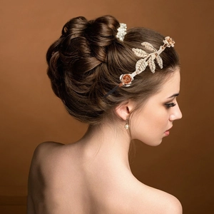 Detailed back view of vintage golden leaf headpiece with orange roses and pearls in hair