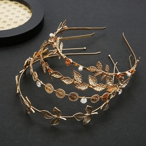 Vintage gold leaf headband set with crystals, pearls and coins on a black background