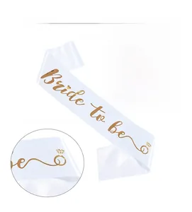 Detail of white satin Bride to Be sash with gold foil lettering and heart ring icons