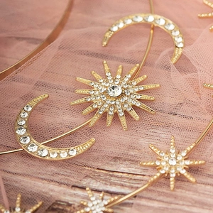 Detail of gold star and moon headband with sparkling crystals on pink tulle backdrop