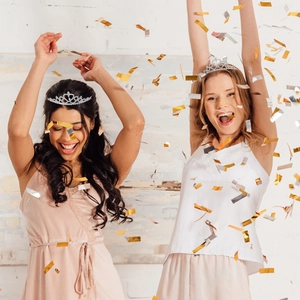 Detailed view of silver crystal tiara with heart pattern on models at a birthday party