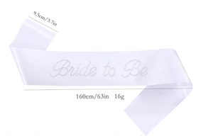 Macro detail of white satin Bride to Be sash with sparkling rhinestone lettering for weddings
