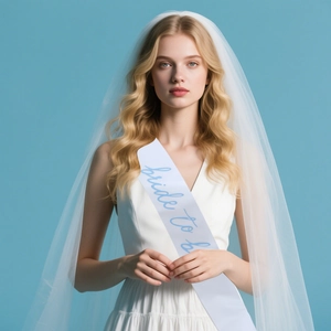 Detail of white bridal sash with blue Bride to be text and layered tulle wedding veil